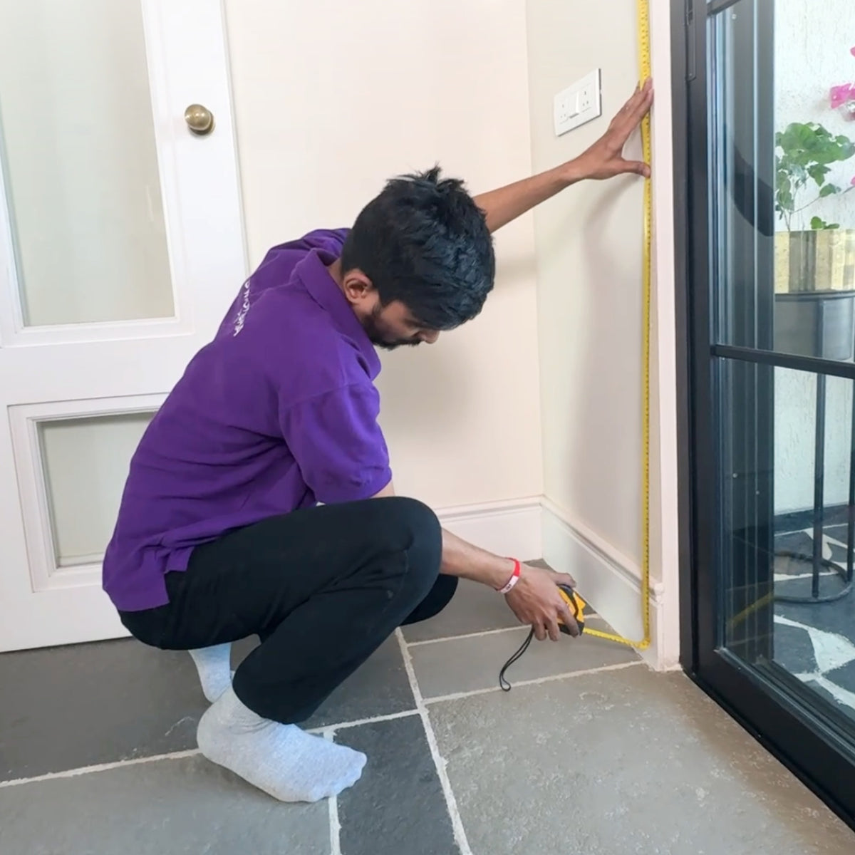 D'Moksha team taking precise window measurements at a client's home